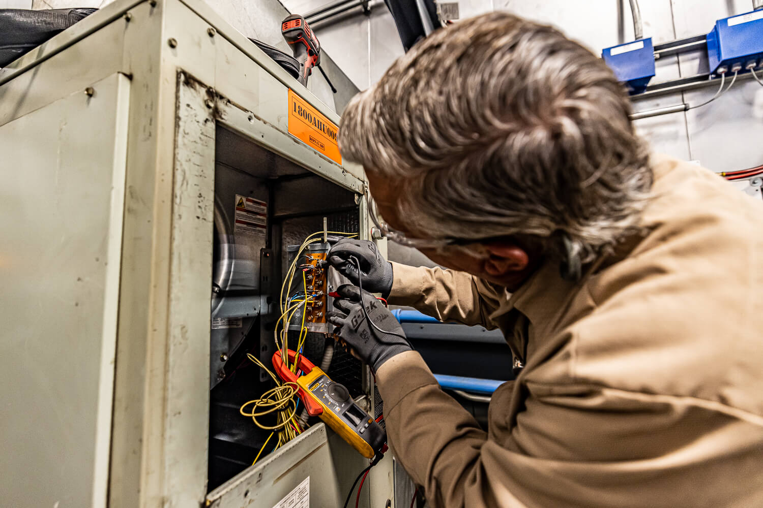 Industrial electrician fixing wires on a work site.