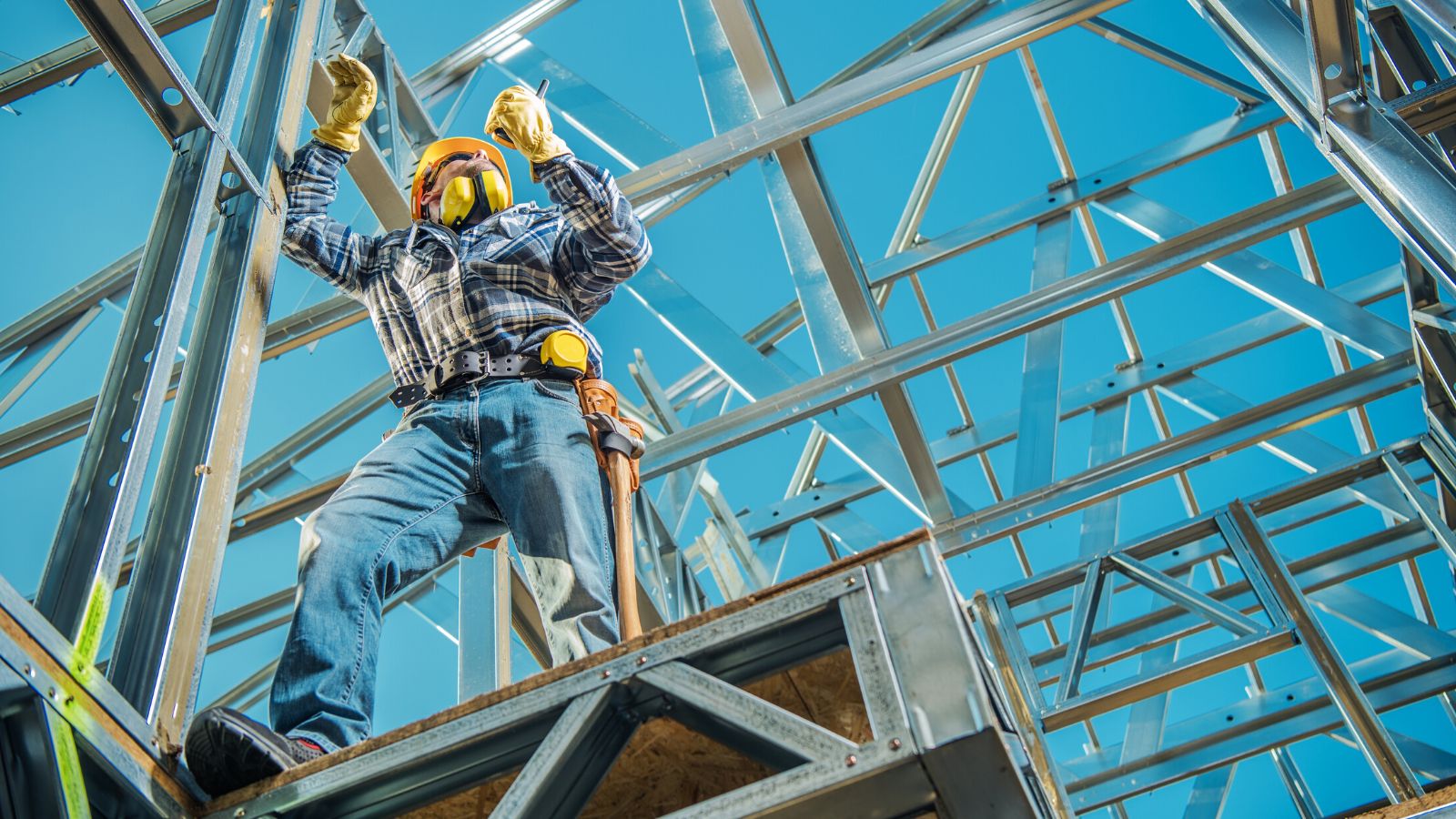 Industrial worker building a steel frame for an industrial building.